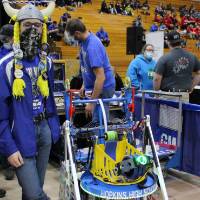 A student team member poses with his team's robot